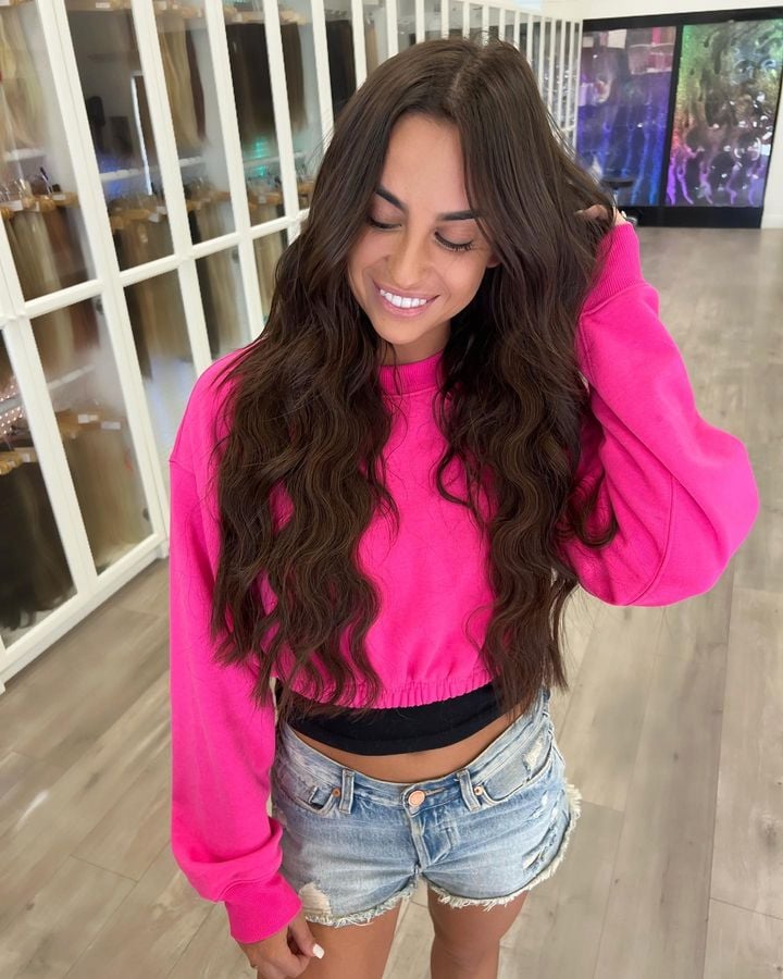 Las Vegas Women Showing Hair Extensions Off After Fresh Install Inside Hottie Hair - Cabinets Stocked With Many Types and Colors of Hair Extensions in the Background