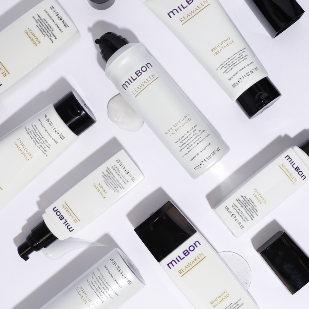 MILBON Reawaken at-home hair care products, including Renewing Shampoo, Renewing Treatment, and Renewing Primer, neatly arranged on a bathroom shelf, designed to restore youthful shine, hydration, and manageability for aging hair.